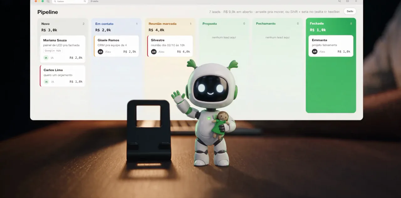 A Liz, robô da Kompila, em cima de uma mesa ao lado de um celular; ao fundo, o pipeline do CRM